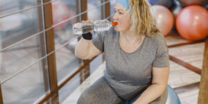 fat-woman-dieting-fitness-lady-sitting-fitball-driking-water